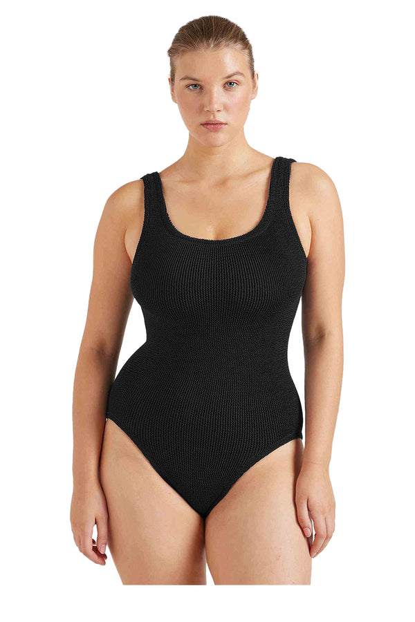 A close-up of a woman wearing Hunza G  swimsuit in black, shown against a plain white background.
