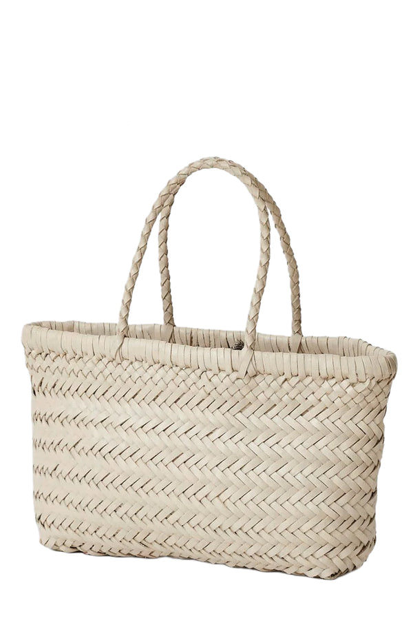Rotated view of Dragon Diffusion woven leather tote bag in soft white, shown against a plain white background.