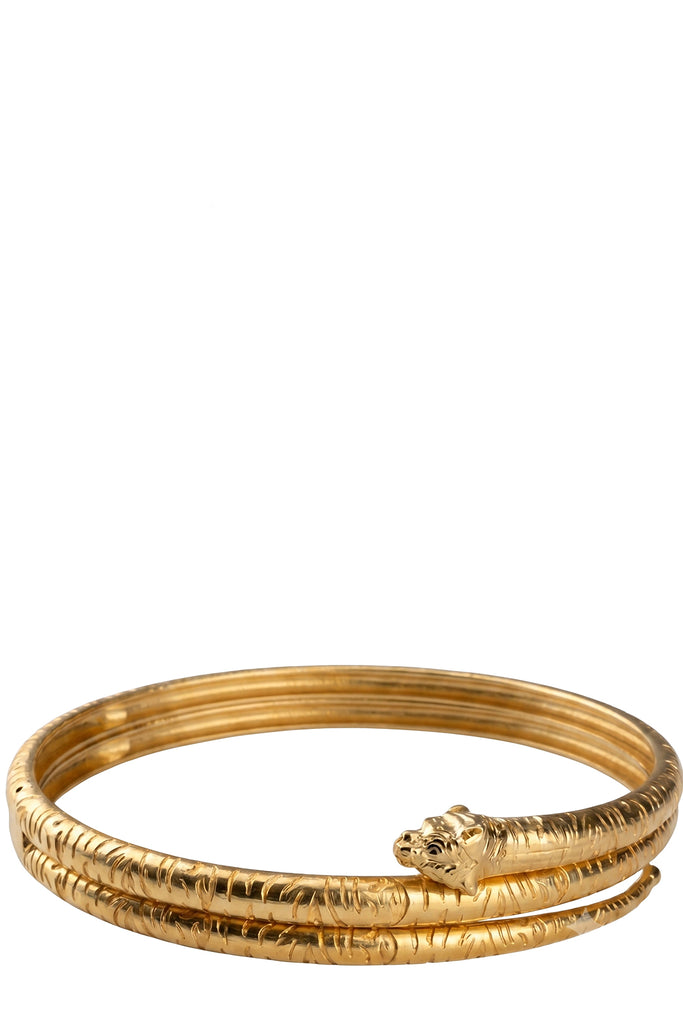 Raquel Diniz metal choker in gold with scratched patterns on the surface, shown against a plaid white background.