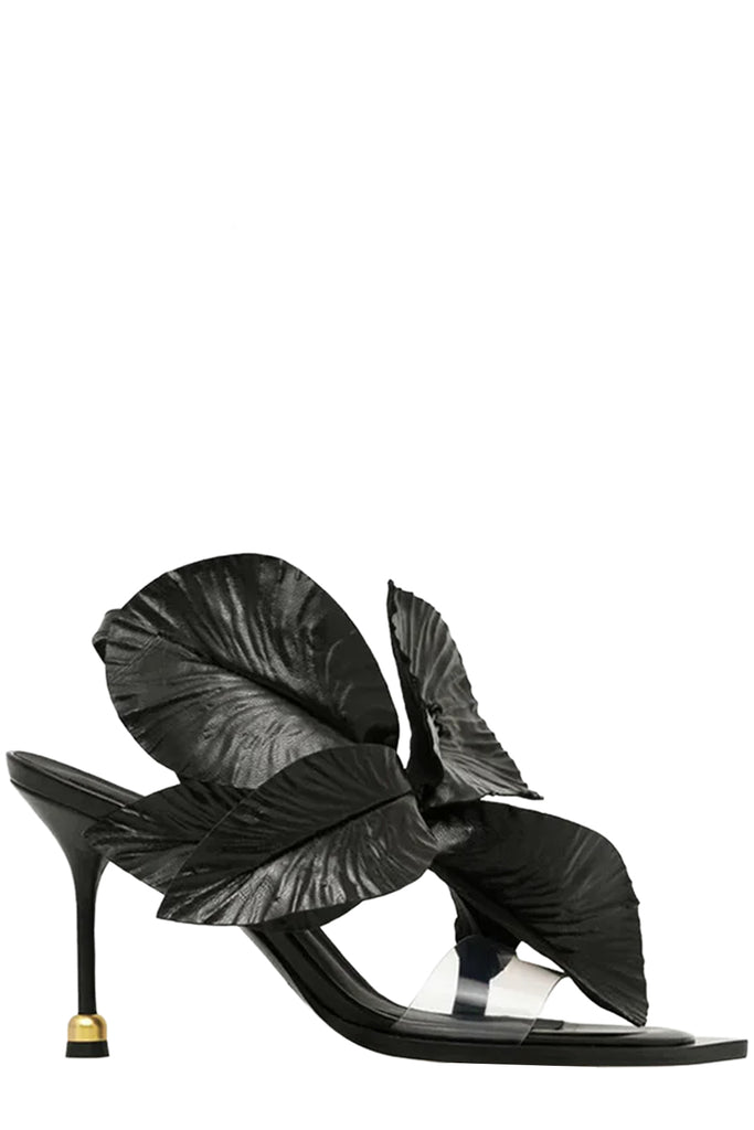 A pair of Vanda Novak high-heels in black with a golden detail made from leather, shown against plaid white background.
