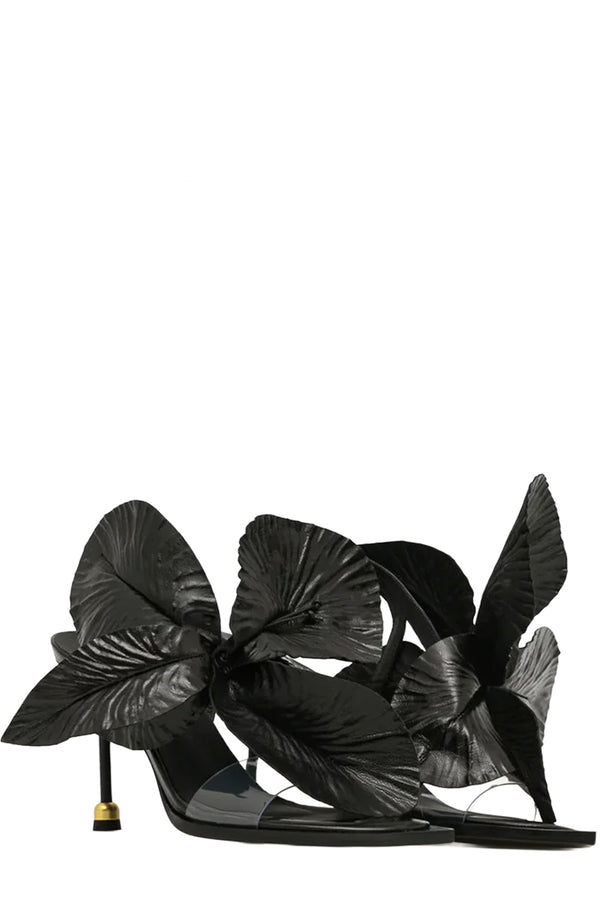 Rotated view of a pair of Vanda Novak high-heels in black with a golden detail made from leather, shown against plaid white background.