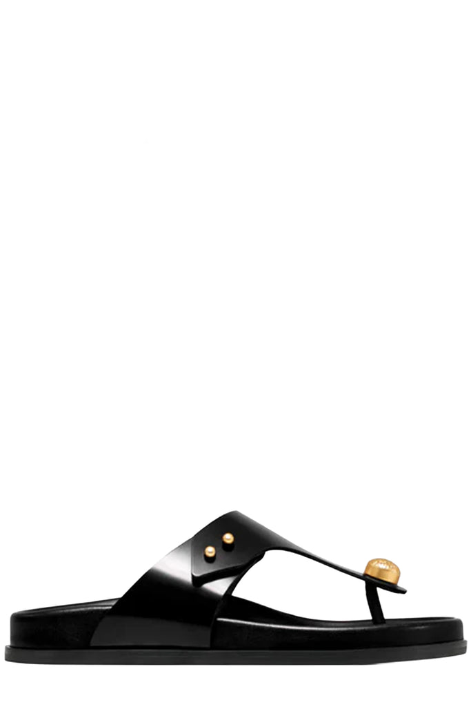 Vanda Novak flat sandals in glossy black made from leather with golden details, shown against plaid white background.