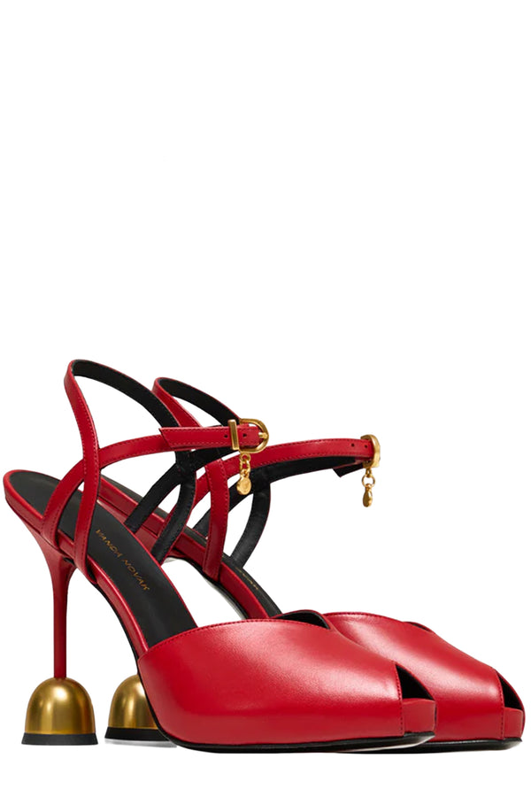Rotated view of a pair of Vanda Novak High heels in red made from leather with golden details, shown against plaid white background.
